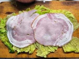 Stendere la verza e aggiungere il prosciutto